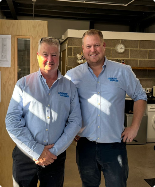 Keith and Ben Southern standing together in the Southern Softflow warehouse wearing branded blue shirts